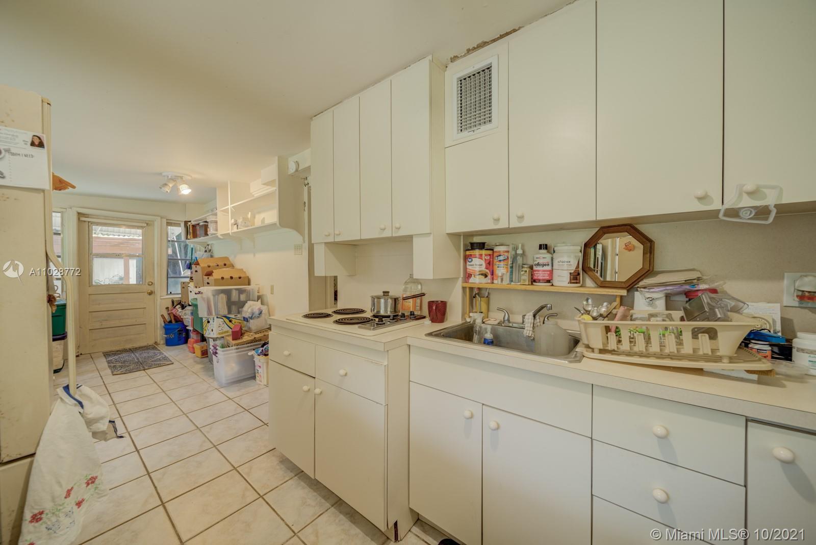 477 Northeast 154th Street Miami, FL 33162 - Photo 6 of 26 a kitchen with sink cabinets and appliances
