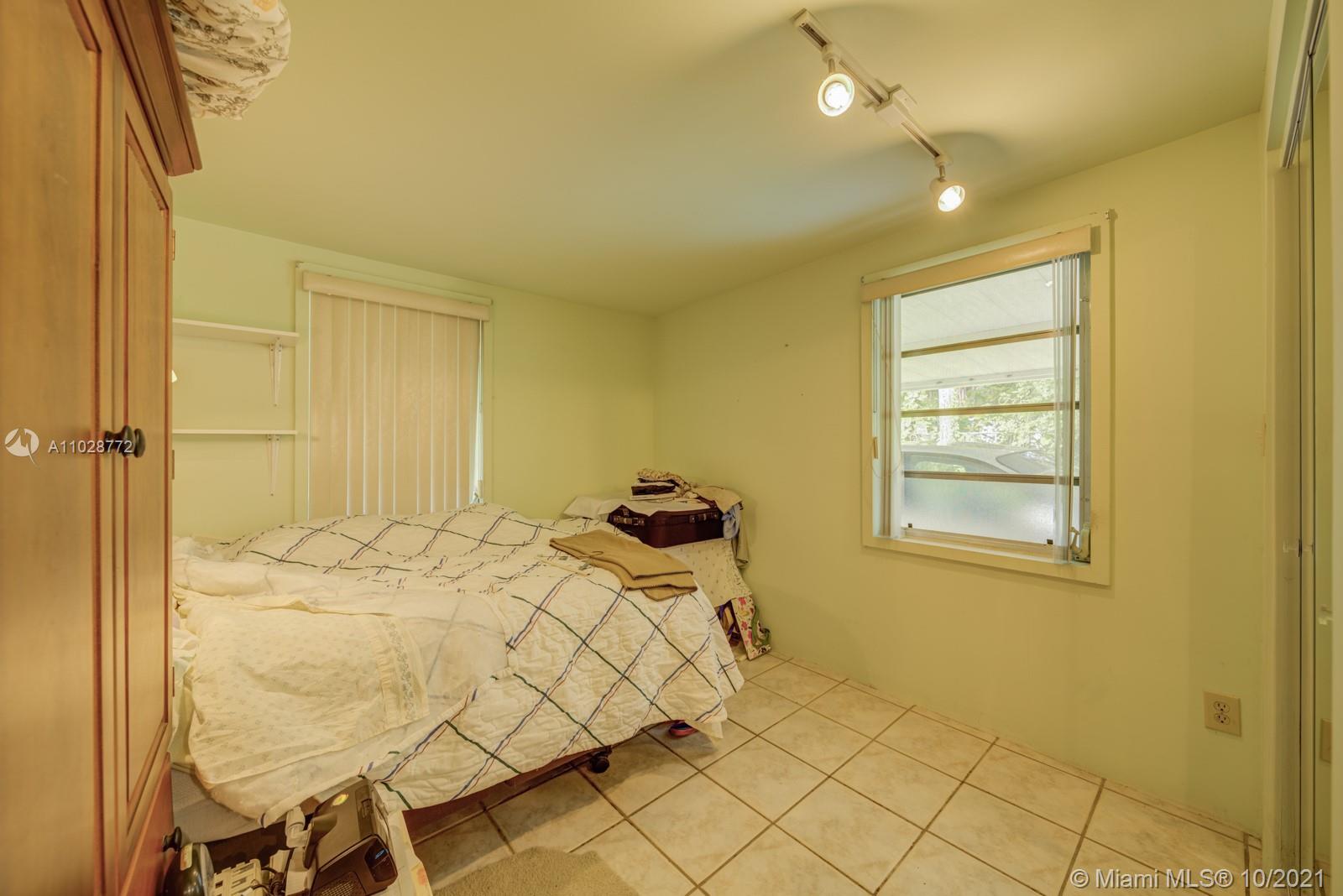 477 Northeast 154th Street Miami, FL 33162 - Photo 7 of 26 a bedroom with a bed and window