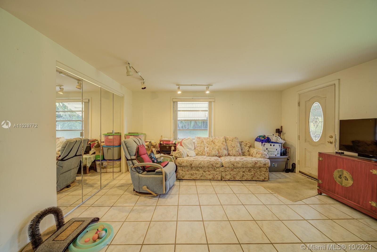 477 Northeast 154th Street Miami, FL 33162 - Photo 8 of 26 a living room with furniture a flat screen tv and a window