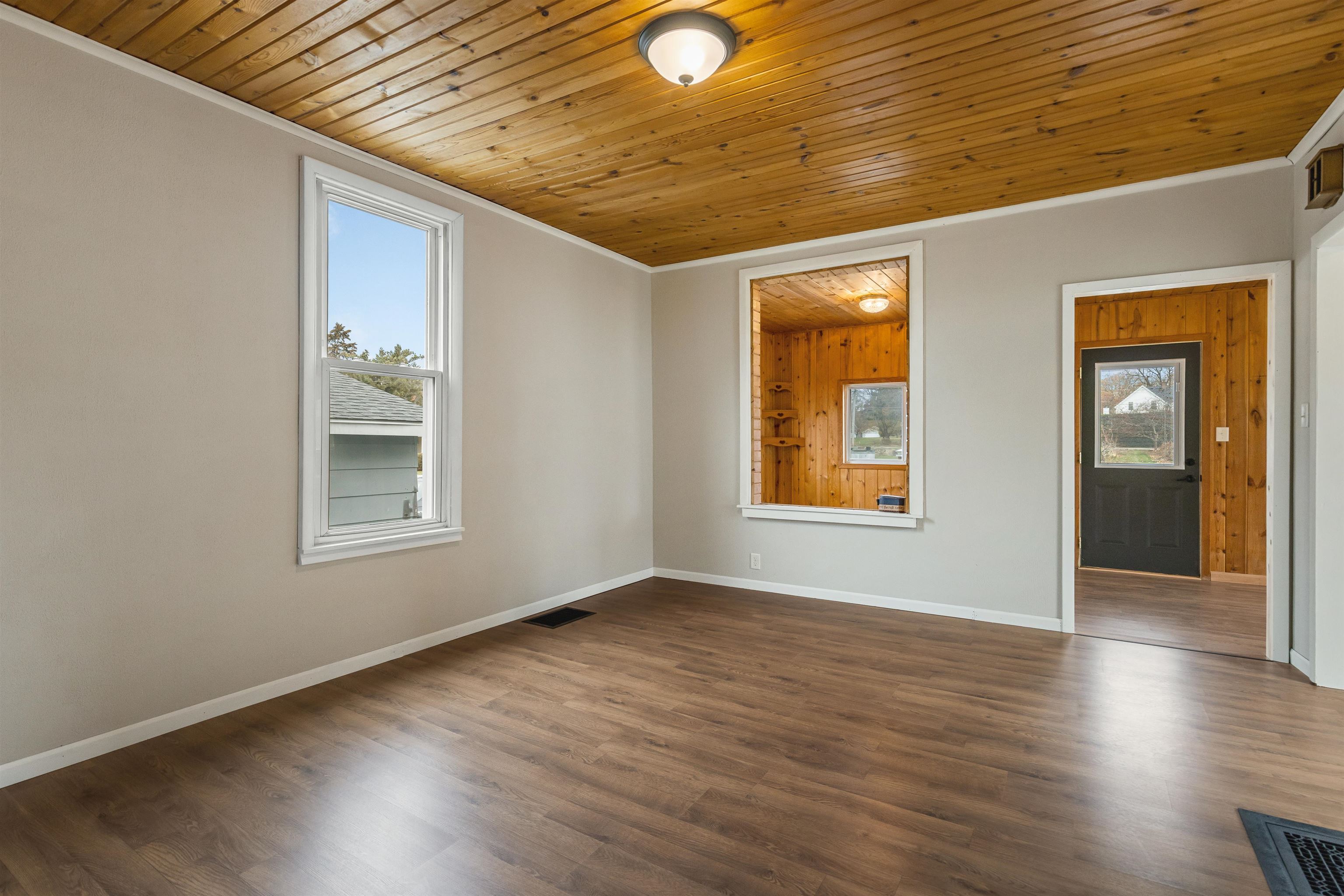 209 South Elida Street Winnebago, IL 61088 - Photo 12 of 48 an empty room with wooden floor and windows