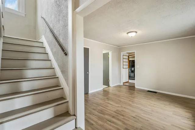 a view of an empty room with wooden floor