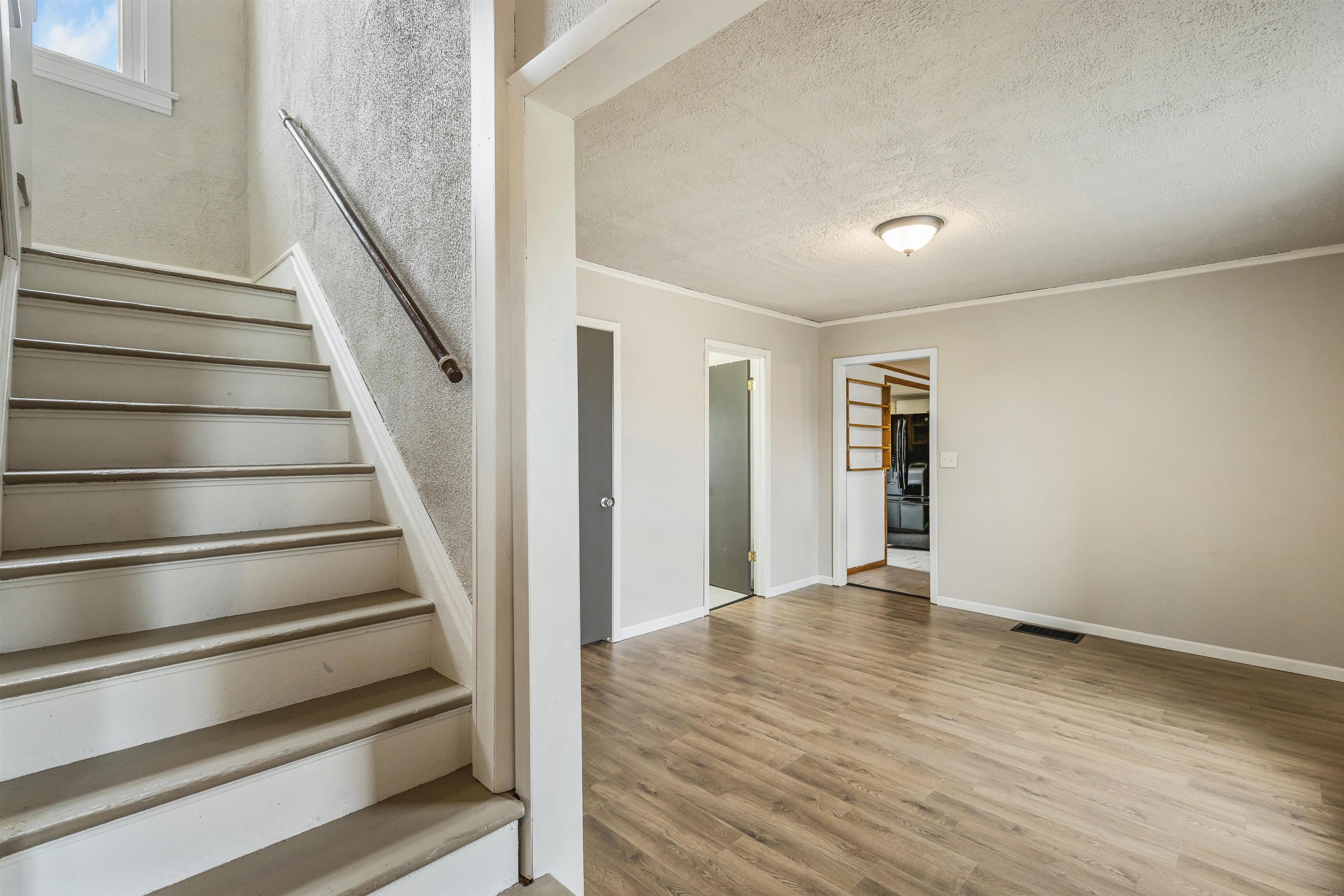 209 South Elida Street Winnebago, IL 61088 - Photo 13 of 48 a view of an empty room with wooden floor and stairs