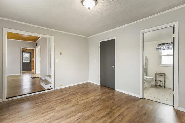 a living room with furniture floor to ceiling window and wooden floor