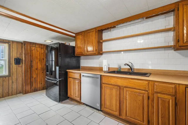 a view of a kitchen with fridge and wooden floor