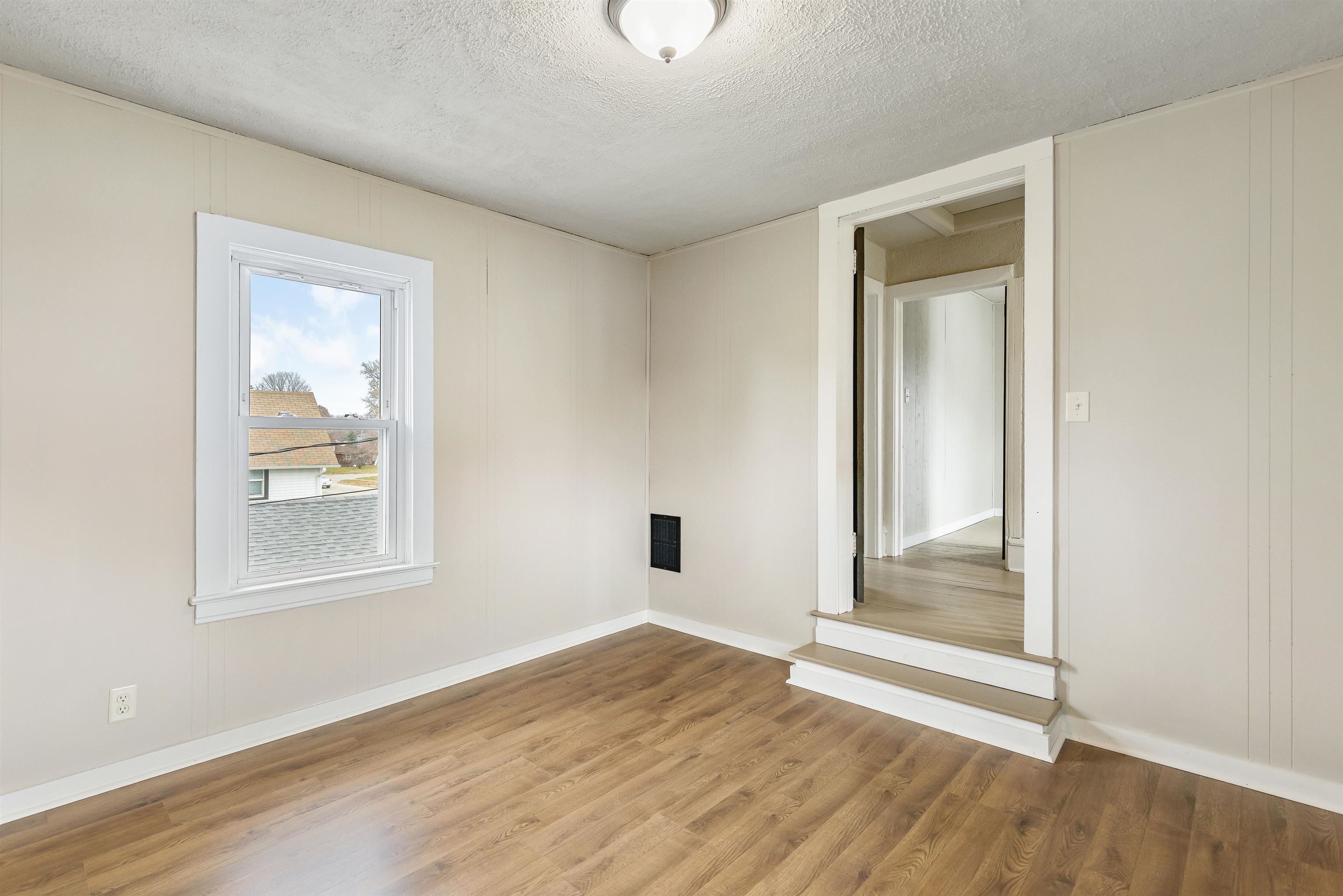 209 South Elida Street Winnebago, IL 61088 - Photo 27 of 48 an empty room with wooden floor and windows