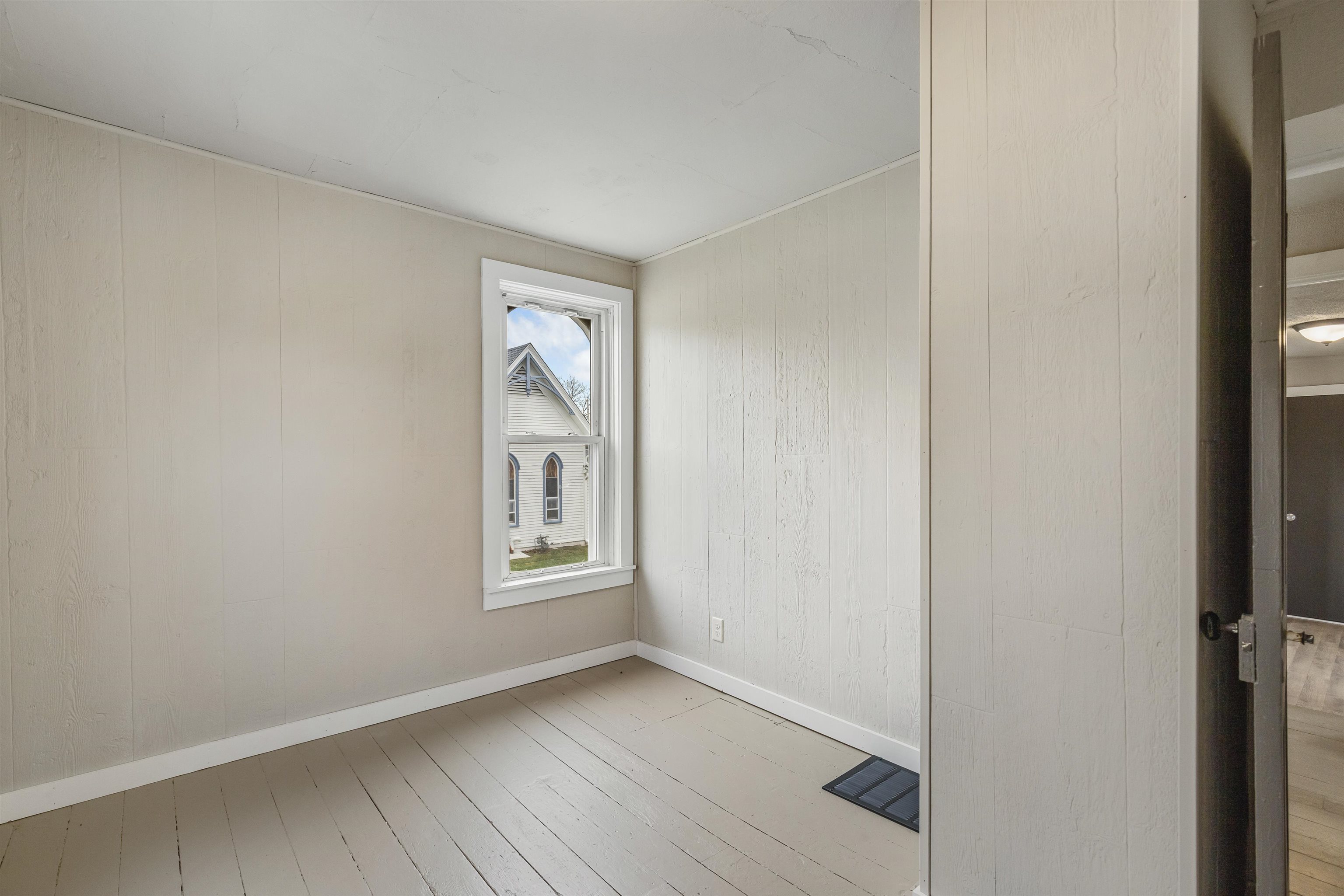 209 South Elida Street Winnebago, IL 61088 - Photo 31 of 48 a view of an empty room with wooden floor and a window