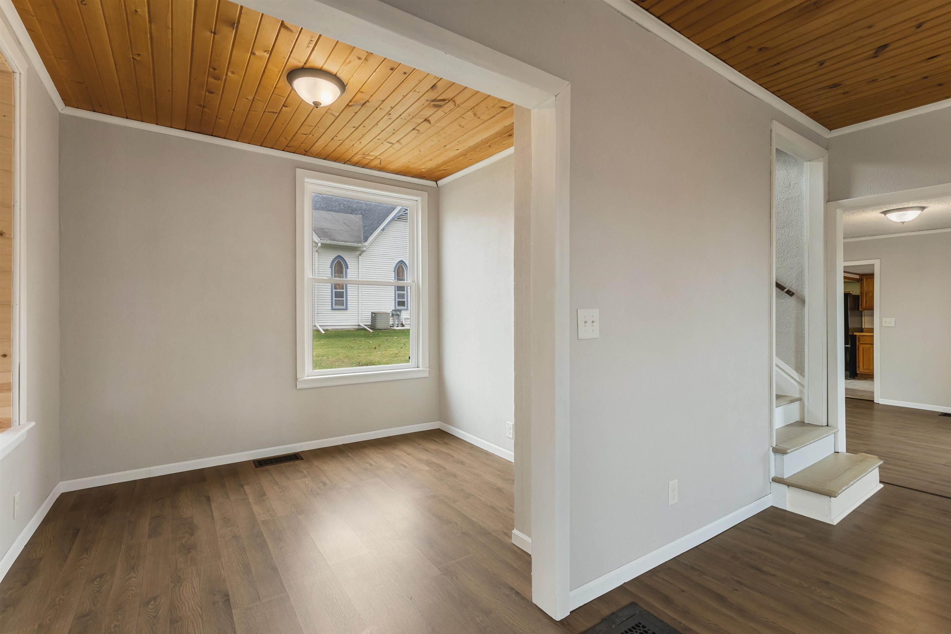 209 South Elida Street Winnebago, IL 61088 - Photo 9 of 48 a view of an empty room with wooden floor and a window