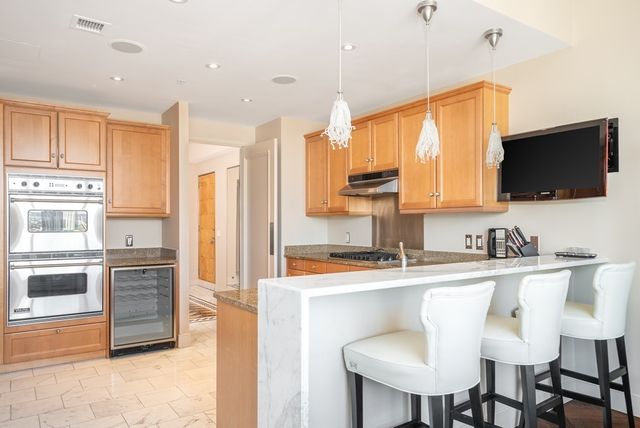 a kitchen with stainless steel appliances kitchen island granite countertop a sink and cabinets