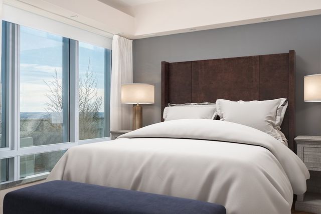 a bedroom with a bed and a large window