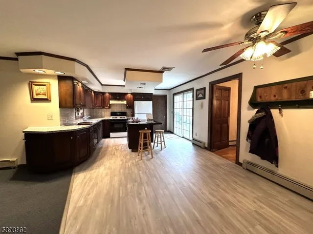 a living room with stainless steel appliances kitchen island granite countertop furniture and a mirror
