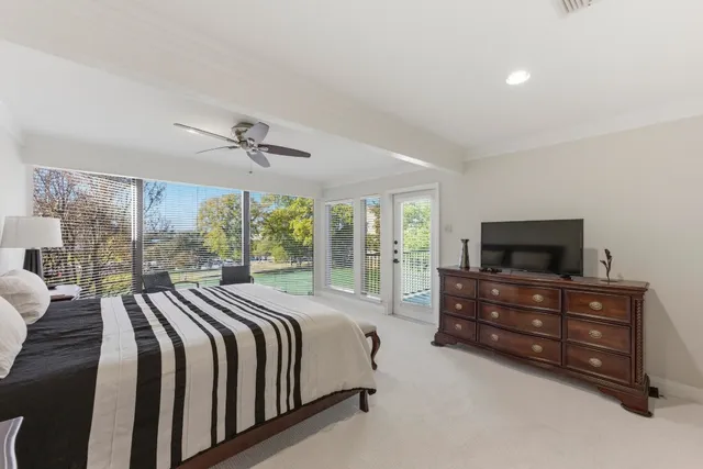 a spacious bedroom with a bed and large windows