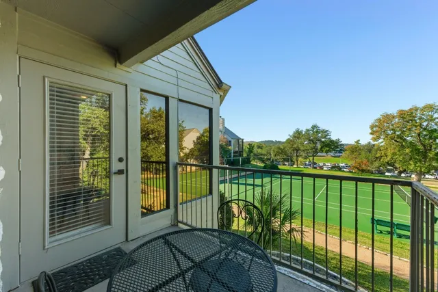 a view of a balcony with floor to ceiling window and wooden fence