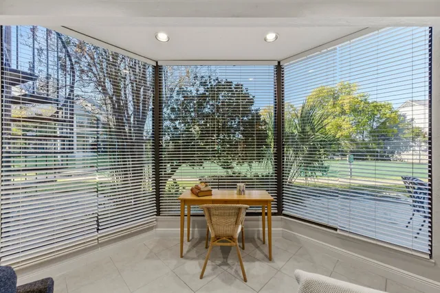 a patio with table and chairs and potted plants