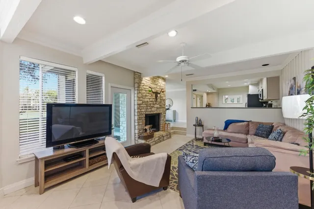 a living room with furniture a flat screen tv and a fireplace