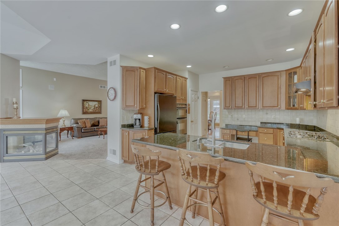 67 Angels Path Penfield, NY 14580 - Photo 16 of 47 KITCHEN . .VIEW OF 2-SIDED FIREPLACE * TILE FLOOR