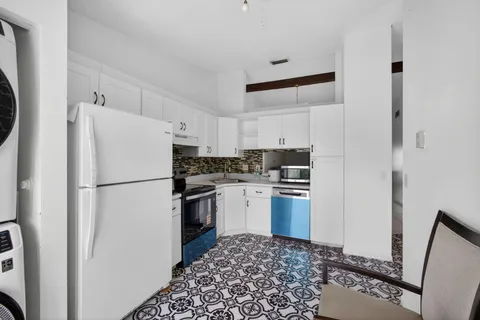 a white refrigerator freezer and a stove sitting inside of a kitchen