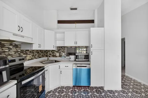 a kitchen with a sink a stove and cabinets