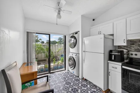 a kitchen with a refrigerator a stove top oven a sink and a large window