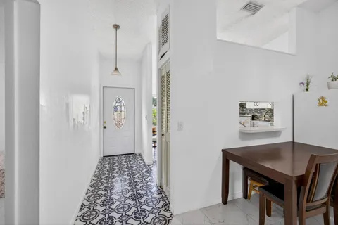 a view of a hallway to a livingroom with furniture and window