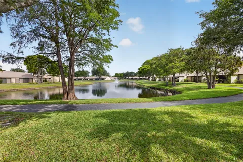 a view of a lake with houses yard and large trees