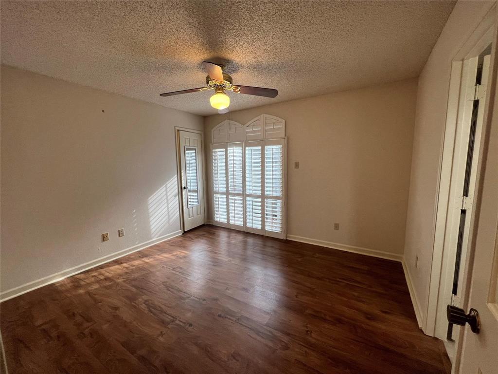 3129 Sappington Place Fort Worth, TX 76116 - Photo 12 of 15 Unfurnished room with dark wood-style flooring, a textured ceiling, and a ceiling fan
