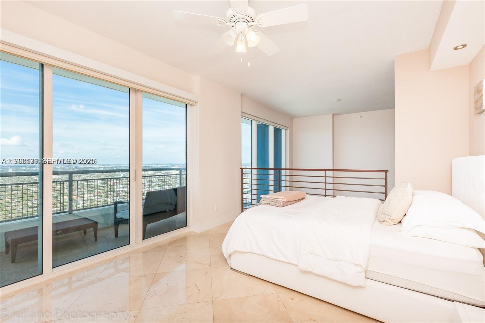 60 Southwest 13th Street, Unit 4205 Miami, FL 33130 - Photo 12 of 14 a bedroom with a large bed and a large window