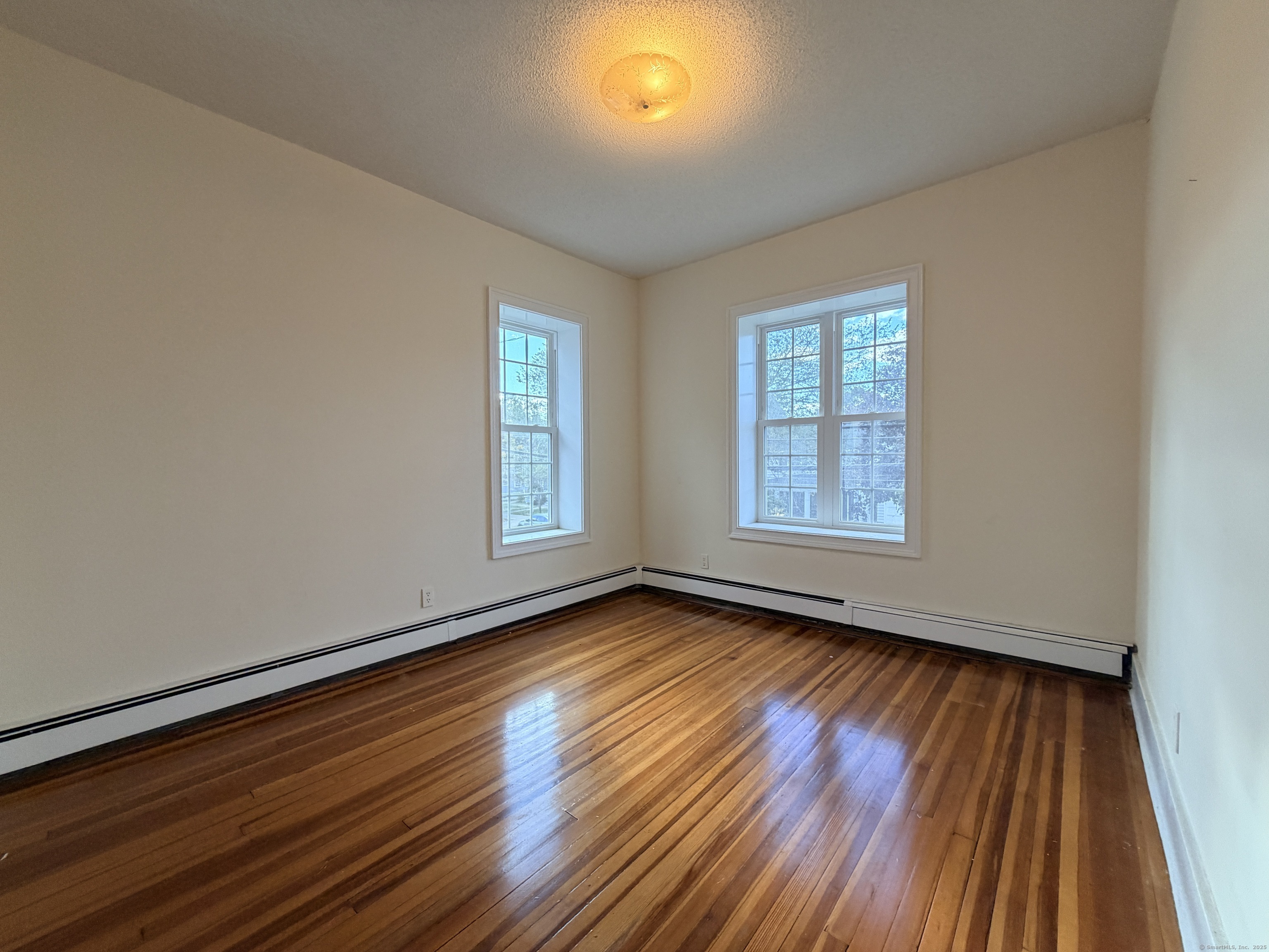 765 Orange Street, Unit 1 New Haven, CT 06511 - Photo 3 of 11 a view of an empty room with wooden floor and a window