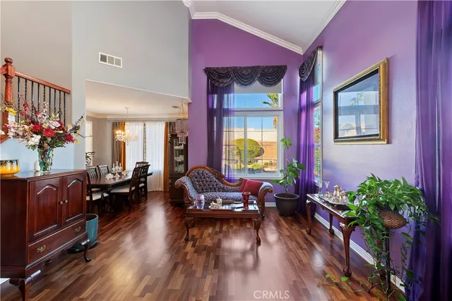 a kitchen with stainless steel appliances granite countertop a refrigerator a stove top oven a sink dishwasher and chairs with wooden floor