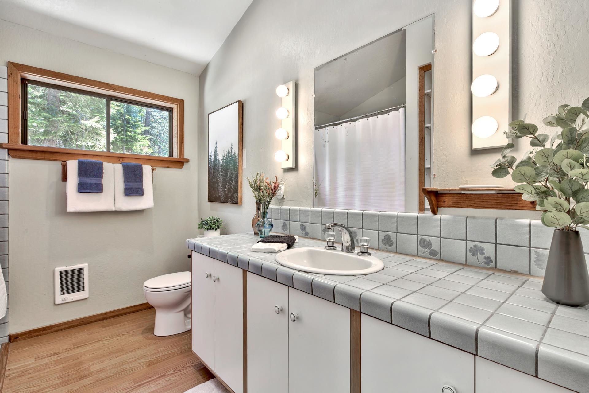 10101 Gregory Place Truckee, CA 96161 - Photo 15 of 21 a bathroom with a double vanity sink toilet and a mirror