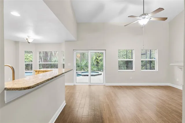 a large white kitchen with granite countertop a large window and stainless steel appliances