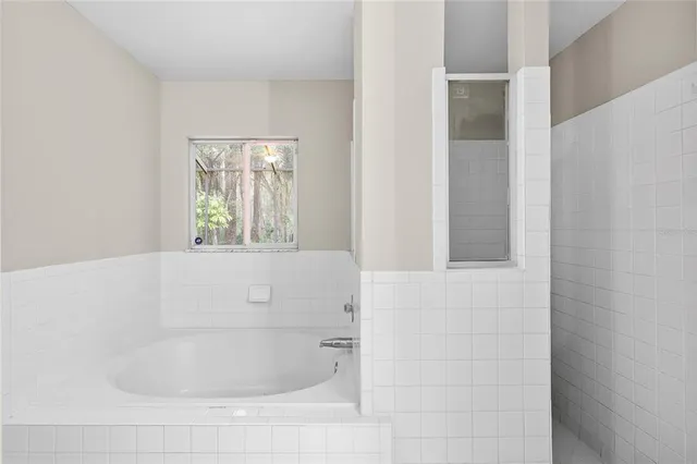 a bathroom with bathtub and window