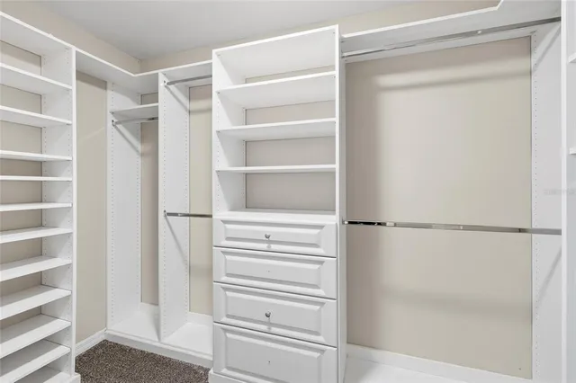 a view of walk in closet with empty racks