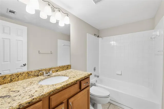 an empty room with windows and ceiling fan