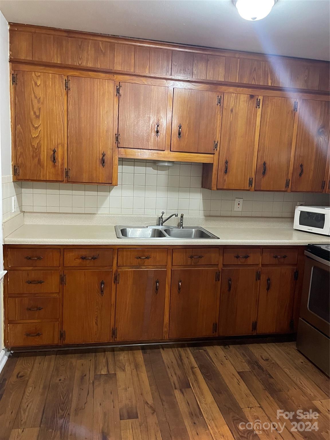 2508 Dora Drive Charlotte, NC 28215 - Photo 16 of 18 a kitchen with granite countertop wooden cabinets and wooden floor