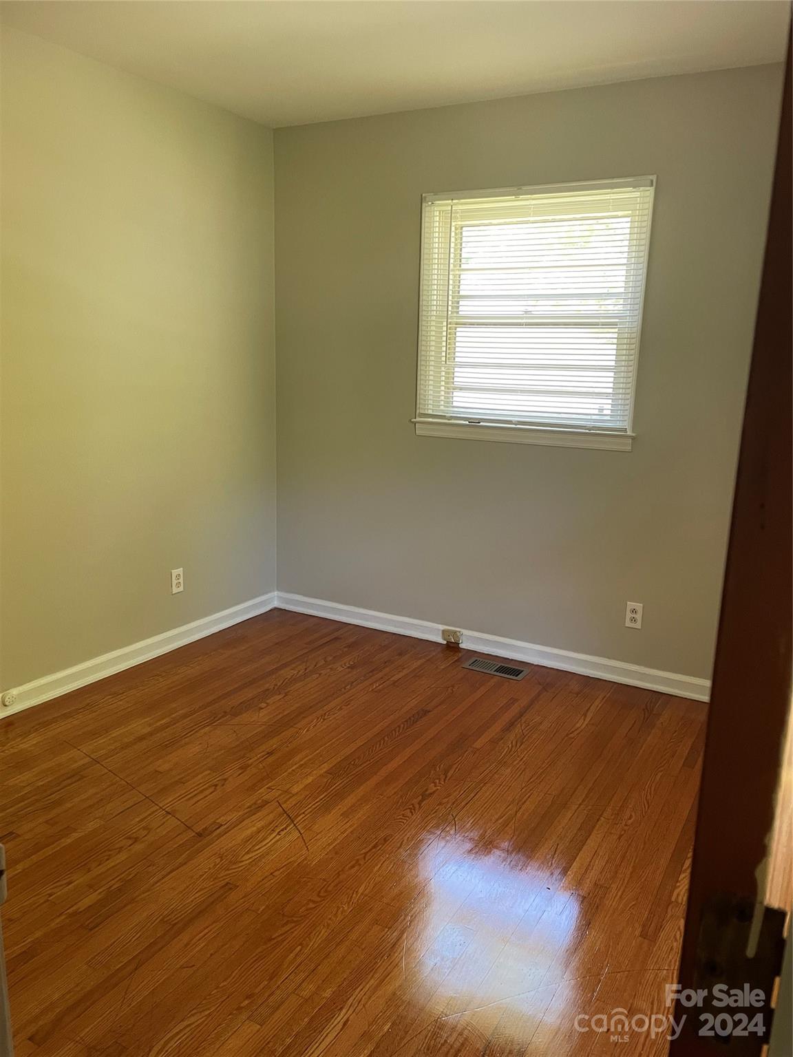 2508 Dora Drive Charlotte, NC 28215 - Photo 4 of 18 an empty room with wooden floor and windows