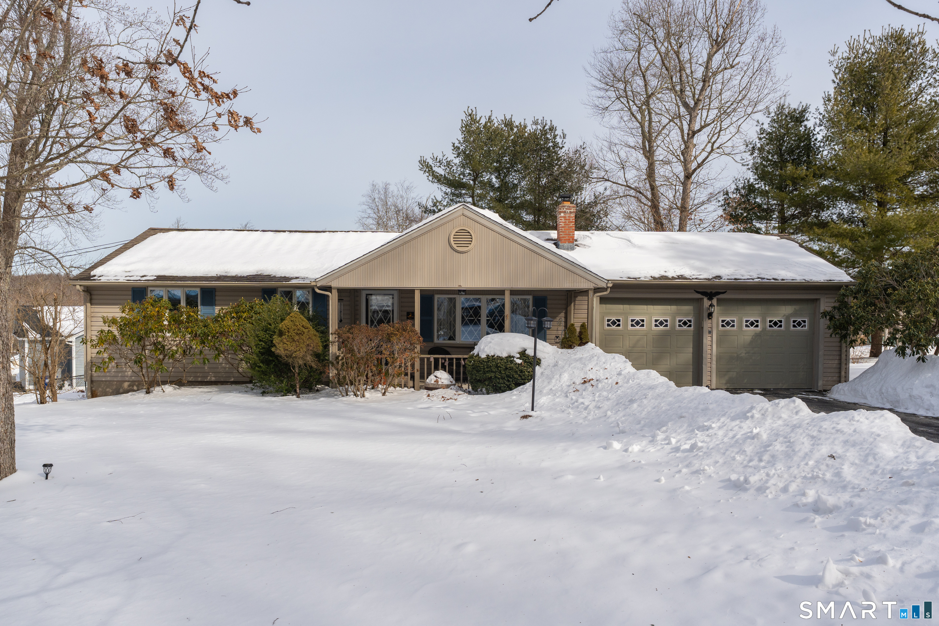 a front view of a house with a yard and trees