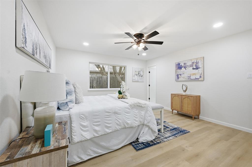 4840 Graham Court The Colony, TX 75056 - Photo 15 of 23 a bedroom with a large bed and a chandelier