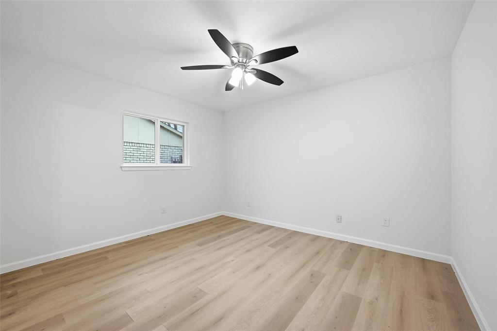 4840 Graham Court The Colony, TX 75056 - Photo 18 of 23 an empty room with wooden floor and windows