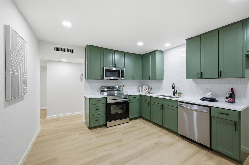4840 Graham Court The Colony, TX 75056 - Photo 10 of 23 a kitchen with stainless steel appliances granite countertop a sink and stove top oven