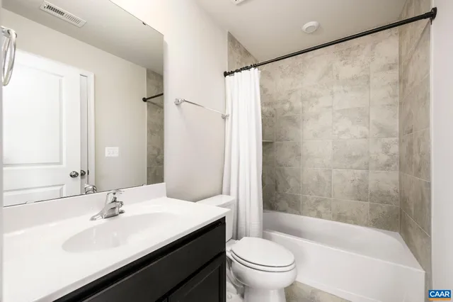 a kitchen with stainless steel appliances kitchen island granite countertop a table chairs and a refrigerator