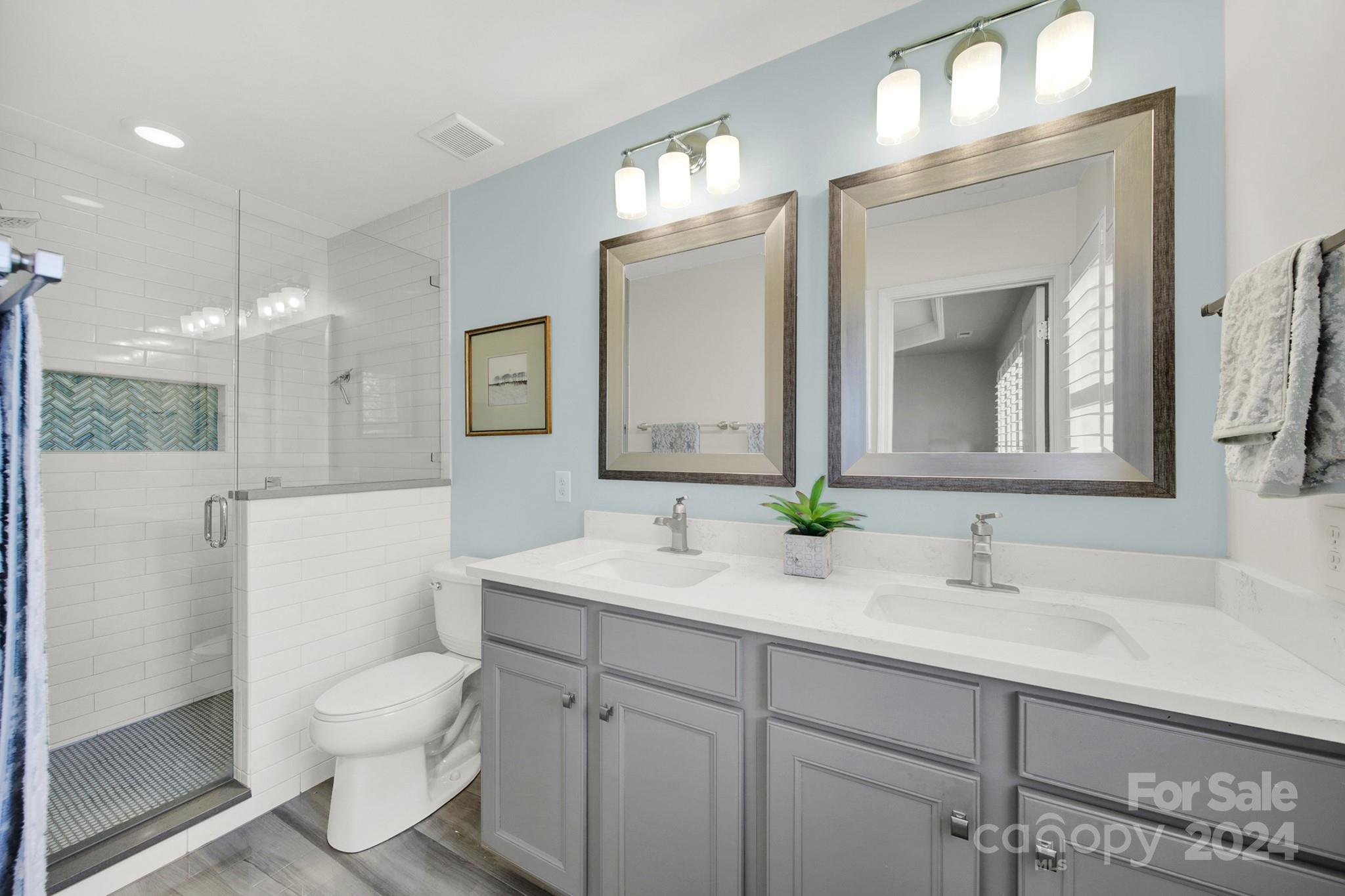 581 6th Baxter Crossing Fort Mill, SC 29708 - Photo 22 of 30 a bathroom with a toilet a sink a mirror and a shower