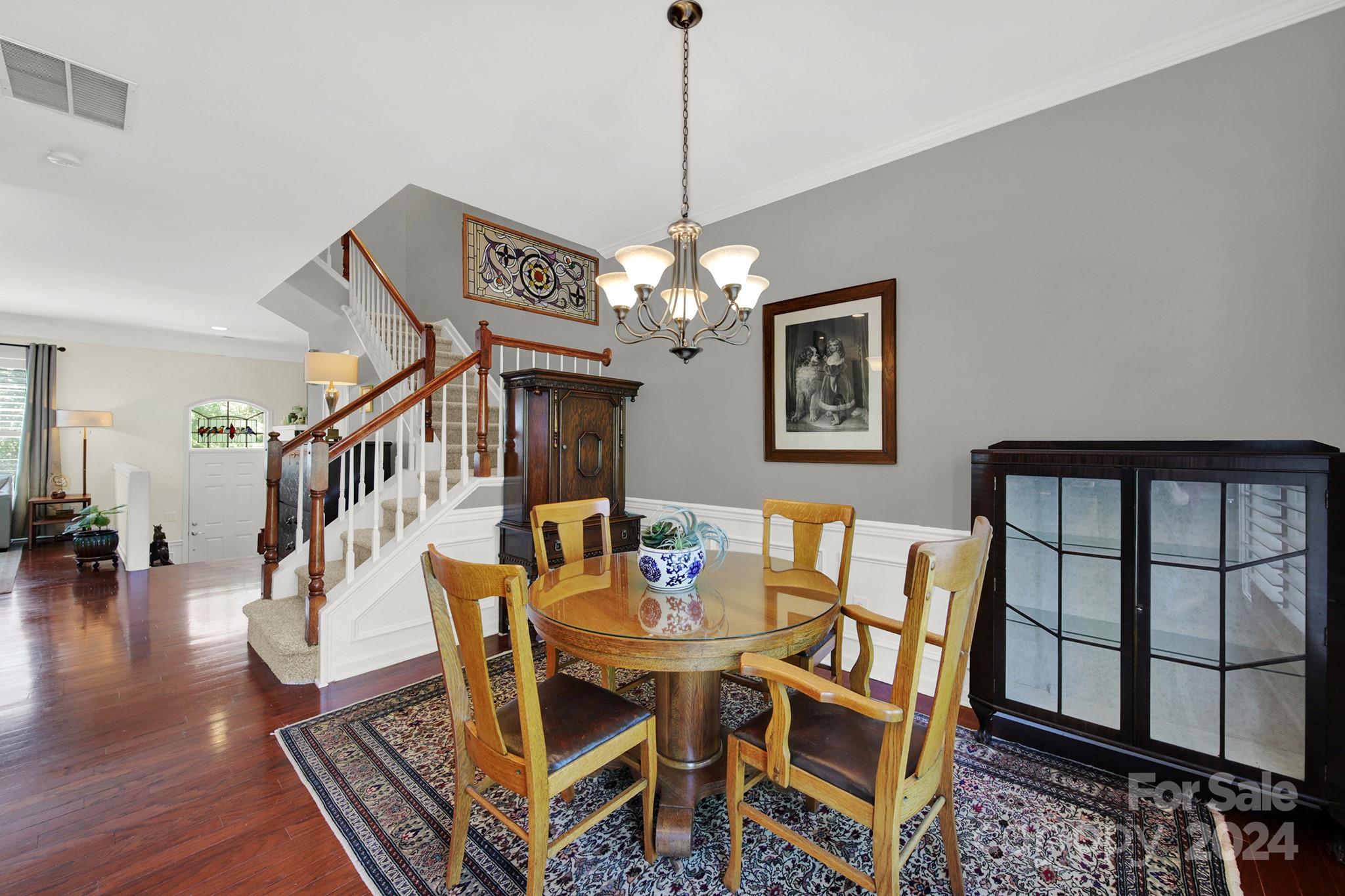 581 6th Baxter Crossing Fort Mill, SC 29708 - Photo 9 of 30 a dining room with wooden floor a chandelier a wooden table and chairs