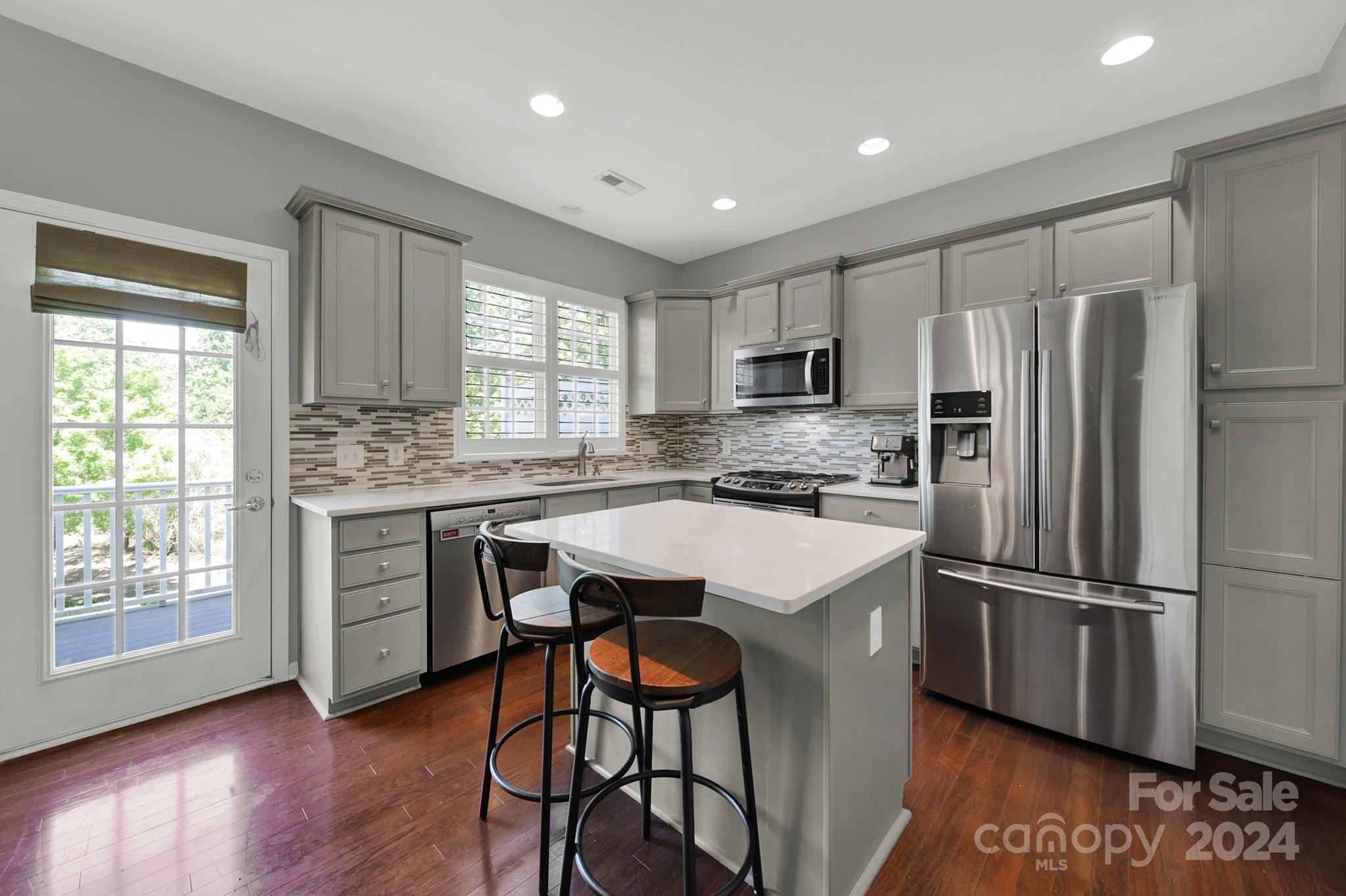 581 6th Baxter Crossing Fort Mill, SC 29708 - Photo 10 of 30 a kitchen with kitchen island granite countertop stainless steel appliances a stove a sink a refrigerator and cabinets