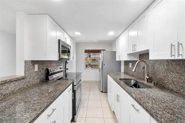 a kitchen with stainless steel appliances granite countertop a sink stove and cabinets