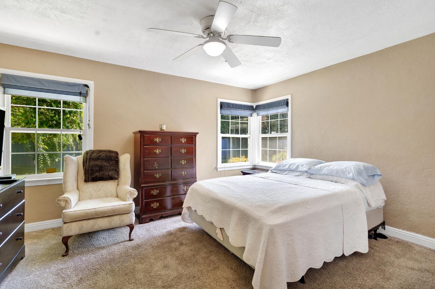 200 Lyons Street Madera, CA 93638 - Photo 18 of 32 a spacious bedroom with a bed and a couch