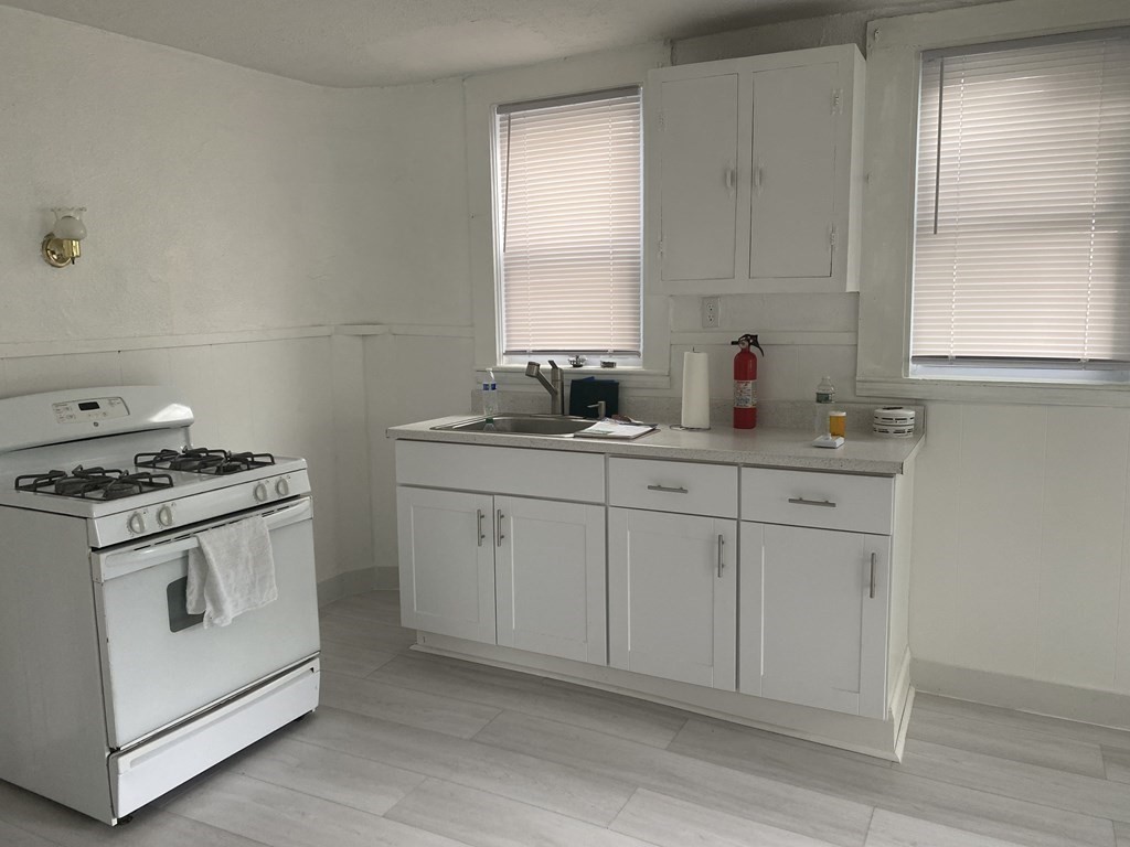 19 Meacham Street, Unit 1 Somerville, MA 02145 - Photo 2 of 11 a kitchen with white cabinets and white appliances