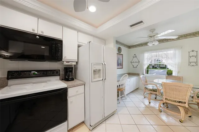 a kitchen with a sink a stove and white cabinets