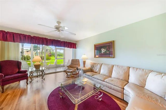 a living room with furniture a rug and a large window