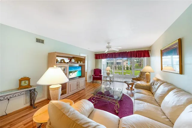a living room with furniture a window and a flat screen tv