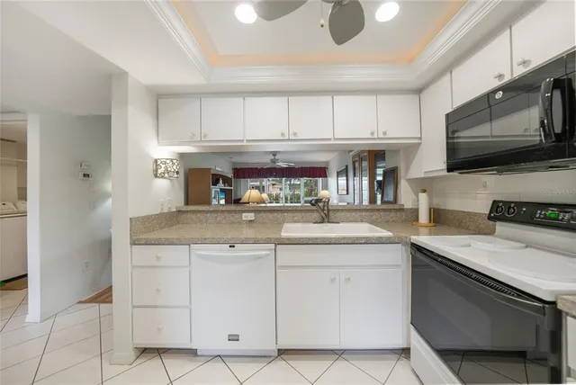 a kitchen with granite countertop white cabinets stainless steel appliances and a sink